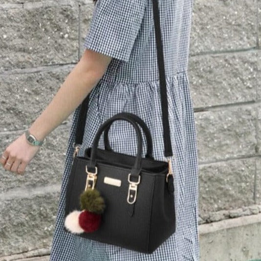 Nora - Schwarze Handtasche mit Pompon-Anhänger