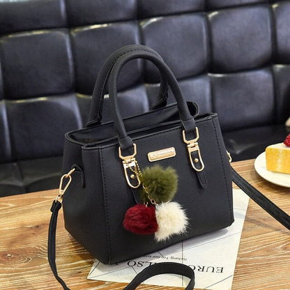 Nora - Schwarze Handtasche mit Pompon-Anhänger